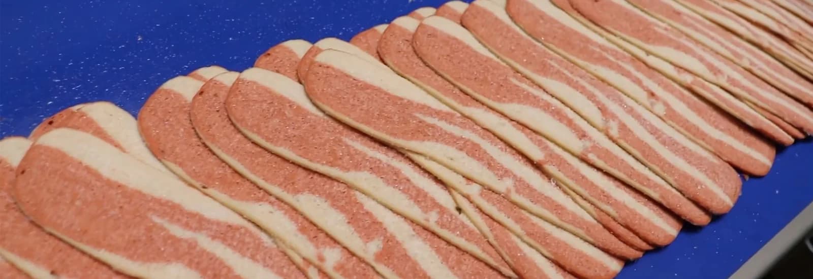Plant-based bacon strips on a conveyor