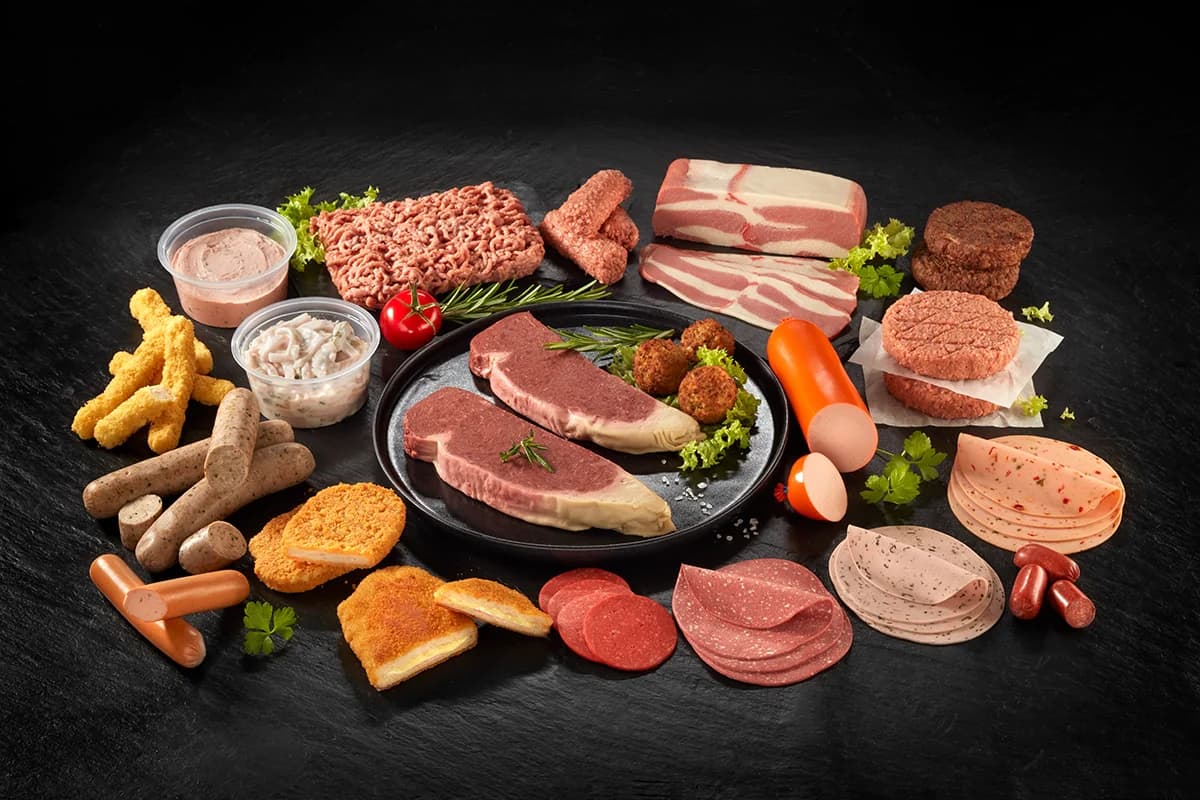 Plant-based and meat products laid out on a dark surface