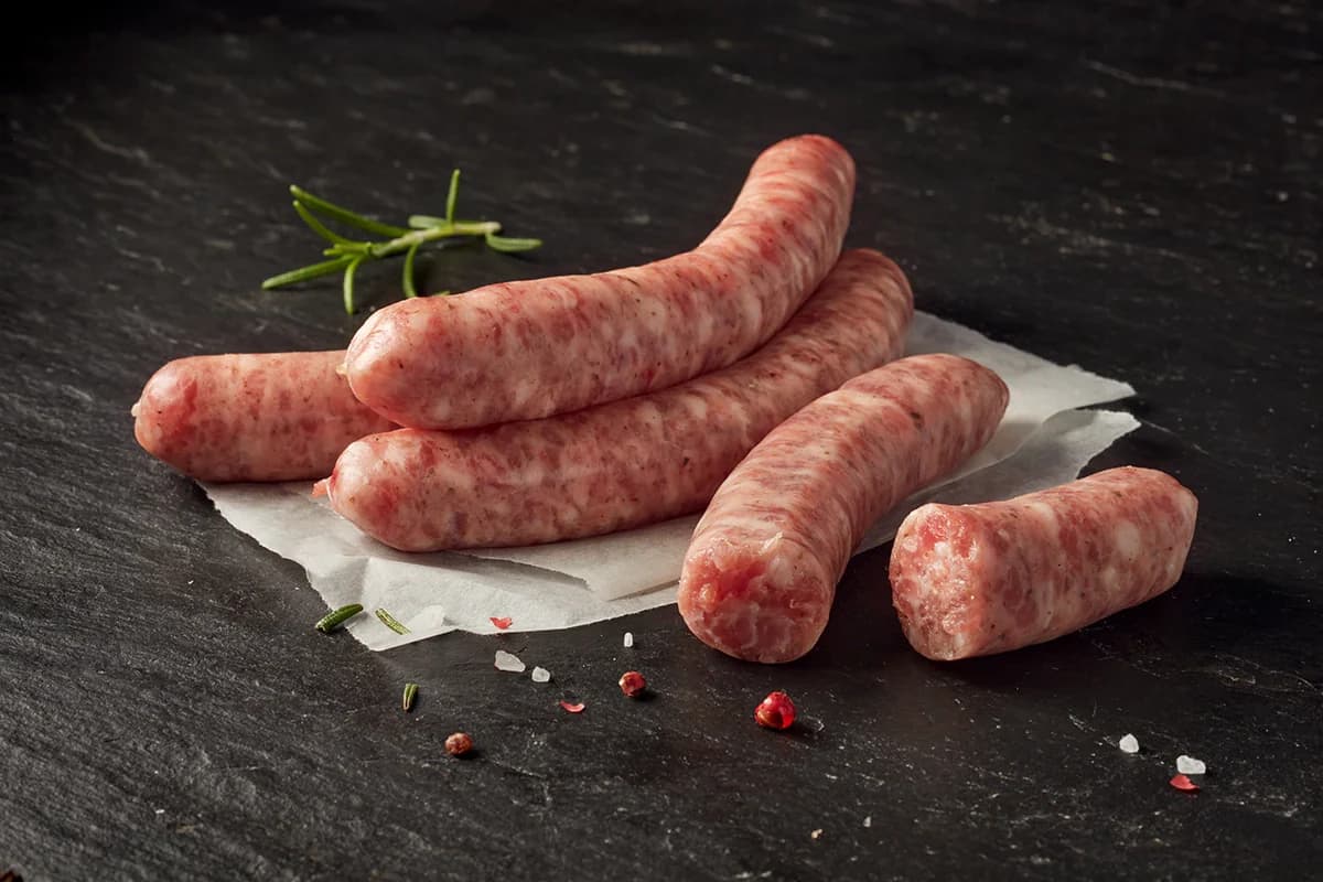 Raw sausages on paper